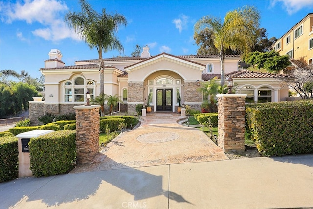 15841 Aurora Crest Dr, Whittier, CA 90605 - mediterranean / spanish-style house with french doors, stucco siding, a chimney, and stone siding