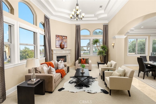 15841 Aurora Crest Dr, Whittier, CA 90605 - living area with arched walkways, a chandelier, crown molding, a raised ceiling, and a glass covered fireplace