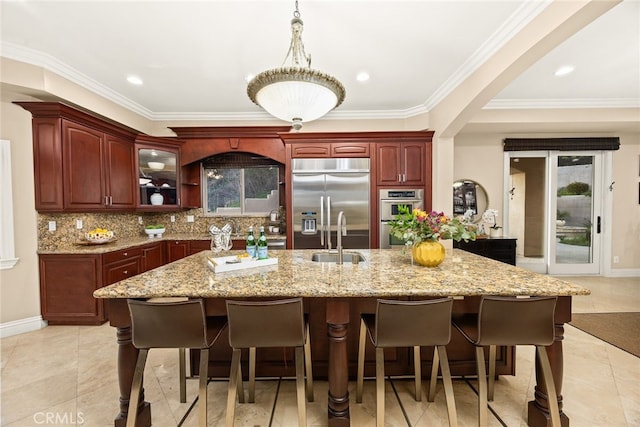 15841 Aurora Crest Dr, Whittier, CA 90605 - kitchen featuring appliances with stainless steel finishes, a sink, dark brown cabinets, a kitchen bar, and backsplash