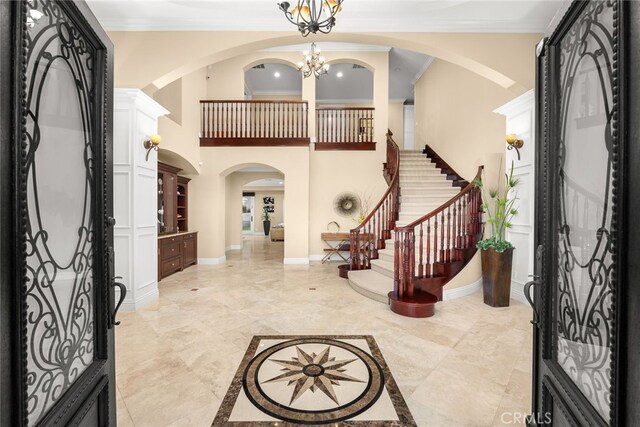 15841 Aurora Crest Dr, Whittier, CA 90605 - foyer entrance featuring arched walkways, stairs, ornamental molding, a chandelier, and baseboards