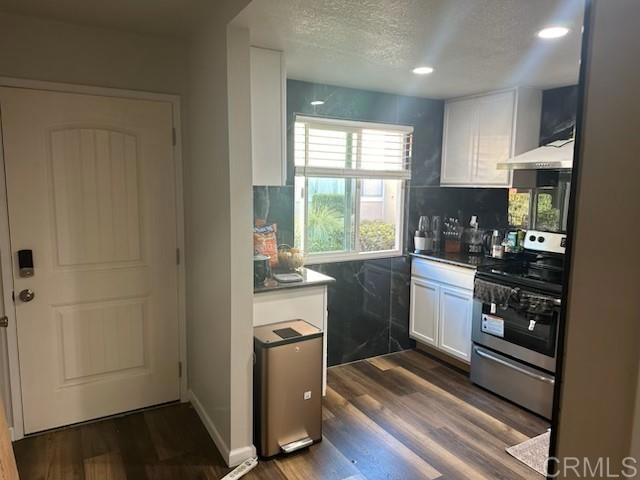 475 N Midway Unit 173, Escondido, CA 92027 - kitchen with stainless steel electric range oven, white cabinets, range hood, dark wood-style floors, and a textured ceiling