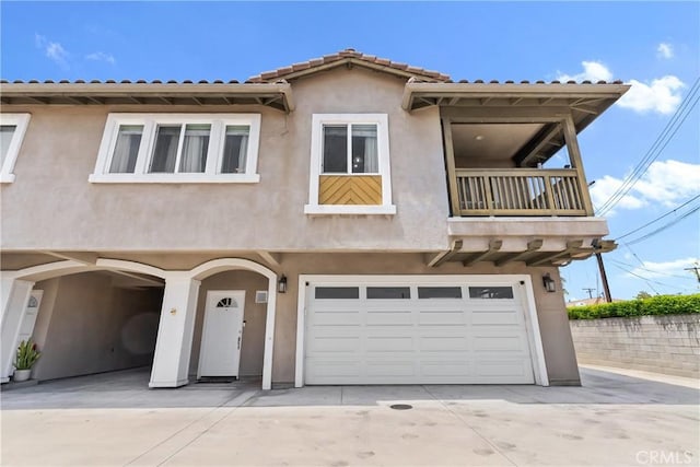247 W 223rd St Unit D, Carson, CA 90745 - view of front of property with a garage, concrete driveway, stucco siding, and a balcony