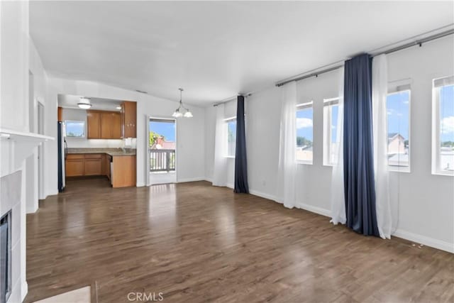 247 W 223rd St Unit D, Carson, CA 90745 - unfurnished living room featuring a fireplace, a chandelier, dark wood finished floors, and baseboards