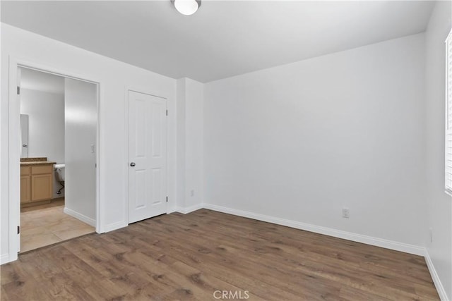 247 W 223rd St Unit D, Carson, CA 90745 - unfurnished bedroom with wood finished floors, baseboards, and connected bathroom