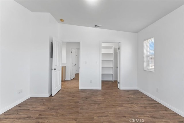 247 W 223rd St Unit D, Carson, CA 90745 - unfurnished bedroom with baseboards, wood finished floors, a walk in closet, and a closet