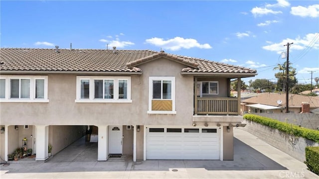 247 W 223rd St Unit D, Carson, CA 90745 - view of front of house with stucco siding, an attached garage, a tile roof, fence, and concrete driveway