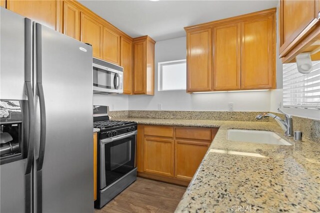 247 W 223rd St Unit D, Carson, CA 90745 - kitchen featuring appliances with stainless steel finishes, a sink, healthy amount of natural light, and light stone counters