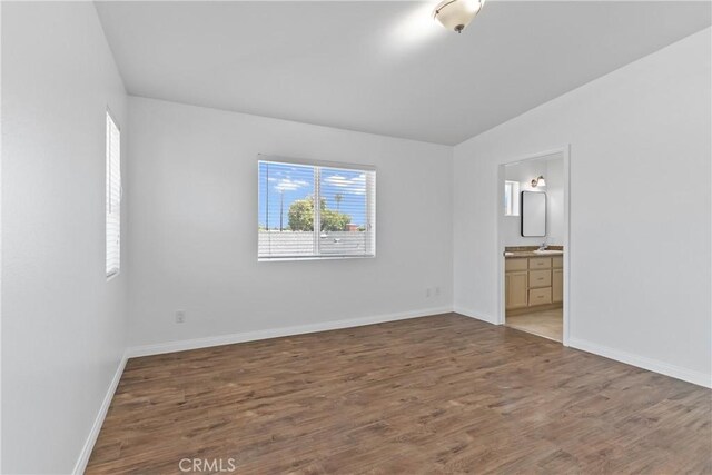 247 W 223rd St Unit D, Carson, CA 90745 - unfurnished bedroom featuring vaulted ceiling, wood finished floors, baseboards, and connected bathroom