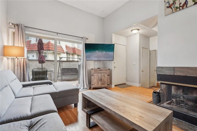 living room featuring wood finished floors, a high ceiling, and baseboards