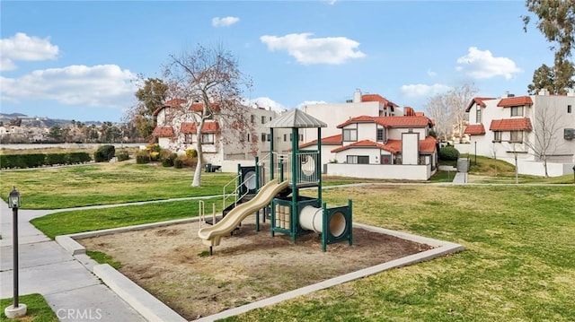 communal playground with a yard and a residential view