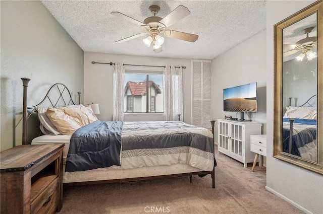 carpeted bedroom with a textured ceiling, baseboards, and ceiling fan