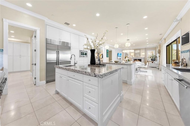 123 Calderon, Irvine, CA 92618 - kitchen with open floor plan, ornamental molding, a center island with sink, and stainless steel appliances