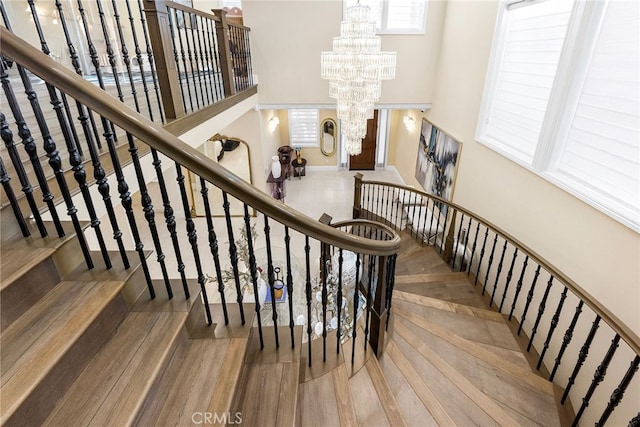123 Calderon, Irvine, CA 92618 - stairs with wood finished floors, a notable chandelier, and a towering ceiling