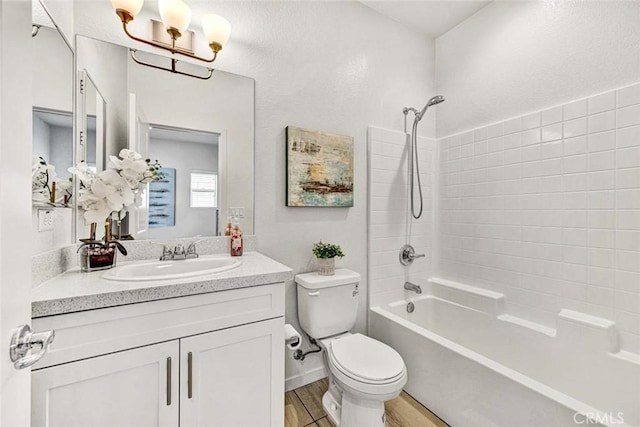 full bath with wood finished floors, vanity, a chandelier, washtub / shower combination, and toilet
