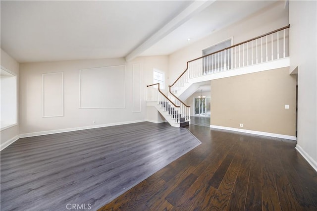 unfurnished living room featuring stairway, wood finished floors, a chandelier, baseboards, and beamed ceiling