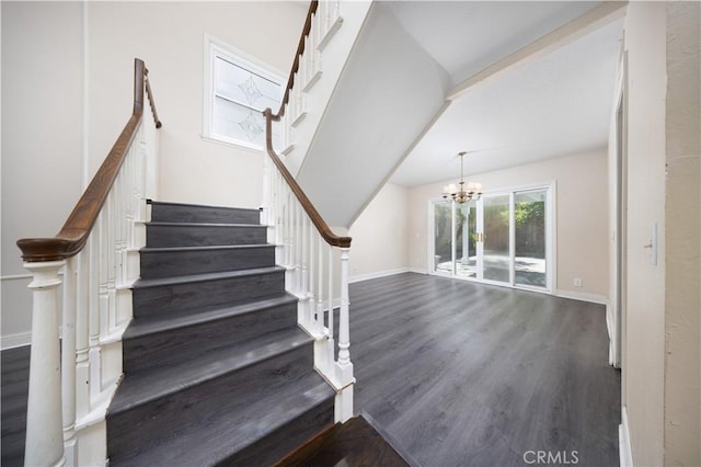 stairway featuring wood finished floors, a chandelier, and baseboards