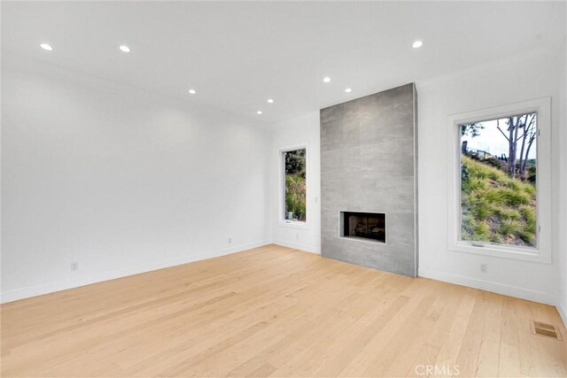 10050 Olivia Ter, Sun Valley, CA 91352 - unfurnished living room with a fireplace, wood finished floors, a wealth of natural light, and recessed lighting