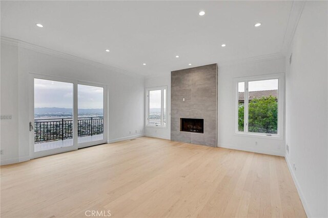 10050 Olivia Ter, Sun Valley, CA 91352 - unfurnished living room with recessed lighting, a tile fireplace, ornamental molding, light wood-style floors, and baseboards