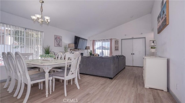dining room featuring vaulted ceiling, light wood-style flooring, baseboards, and a notable chandelier