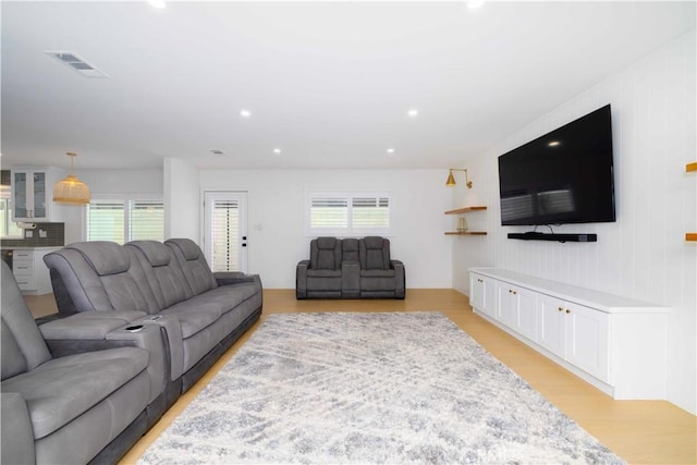 living room with light wood-type flooring, visible vents, and recessed lighting