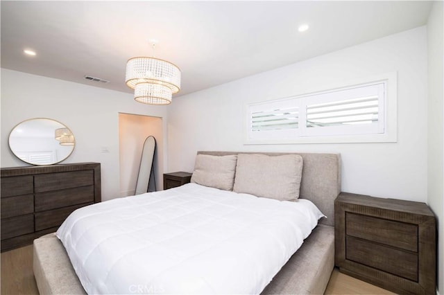 bedroom featuring recessed lighting, a chandelier, wood finished floors, and visible vents
