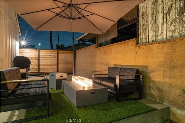 view of patio / terrace with fence, a fire pit, and area for grilling