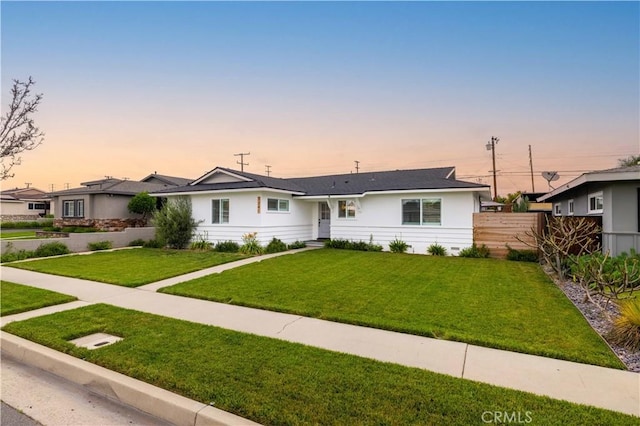 view of front of property with a front lawn and fence