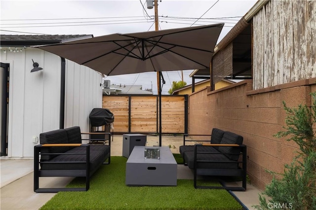 view of patio featuring a fenced backyard and an outdoor living space with a fire pit