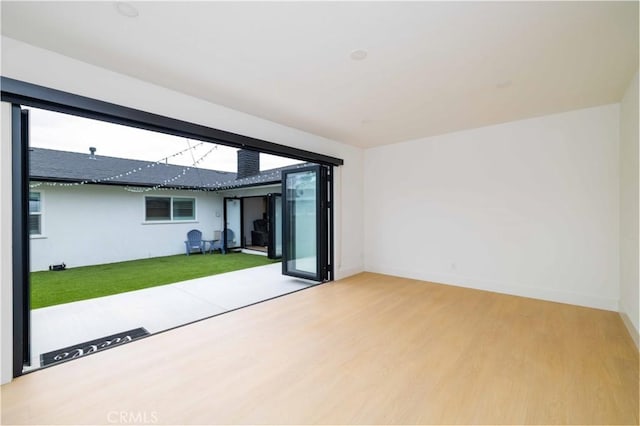spare room featuring baseboards and wood finished floors