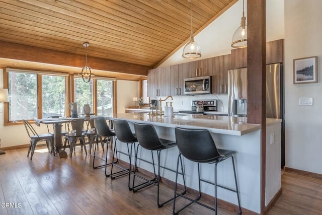 435 Lakeview Blvd Unit 116, Mammoth Lakes, CA 93546 - kitchen with stainless steel appliances, a kitchen bar, wood ceiling, brown cabinetry, and dark wood-style flooring