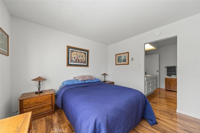 bedroom featuring baseboards and wood finished floors