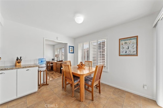 dining room featuring baseboards and light tile patterned flooring