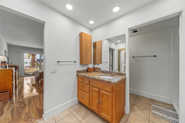 bathroom featuring tile patterned floors, connected bathroom, vanity, baseboards, and recessed lighting