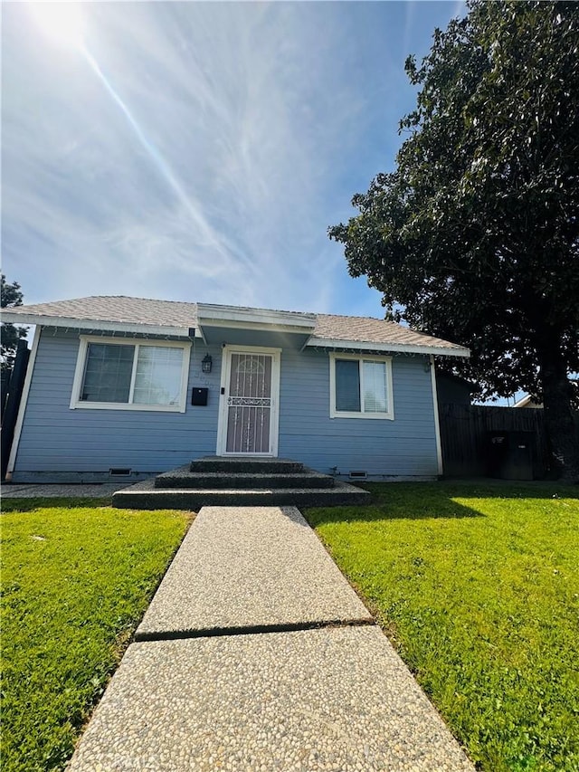 single story home featuring a front lawn and fence