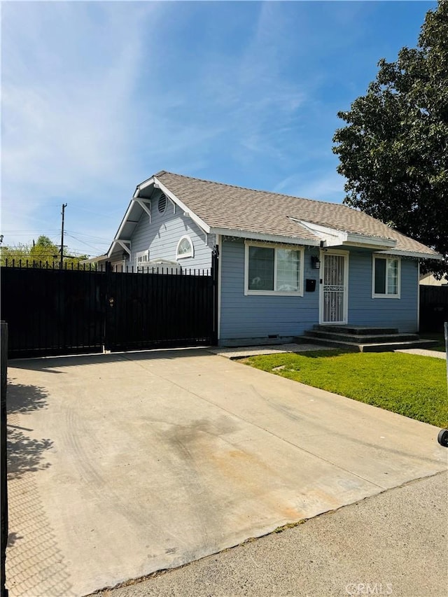 single story home featuring fence, a front lawn, and roof with shingles