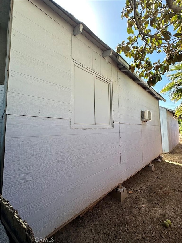 view of property exterior with a wall mounted air conditioner