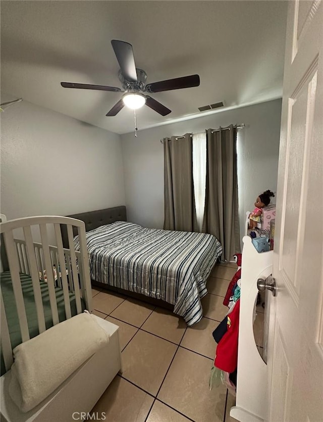 bedroom featuring light tile patterned flooring, visible vents, and ceiling fan