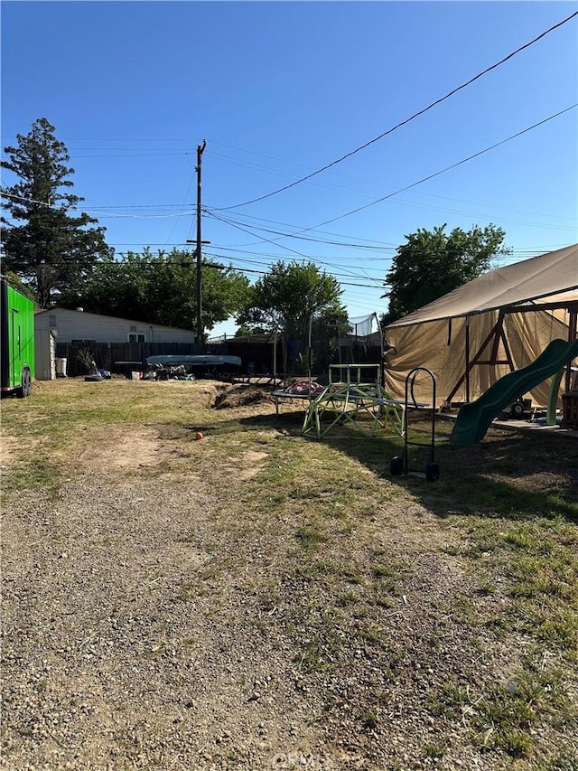 view of yard featuring fence and a trampoline