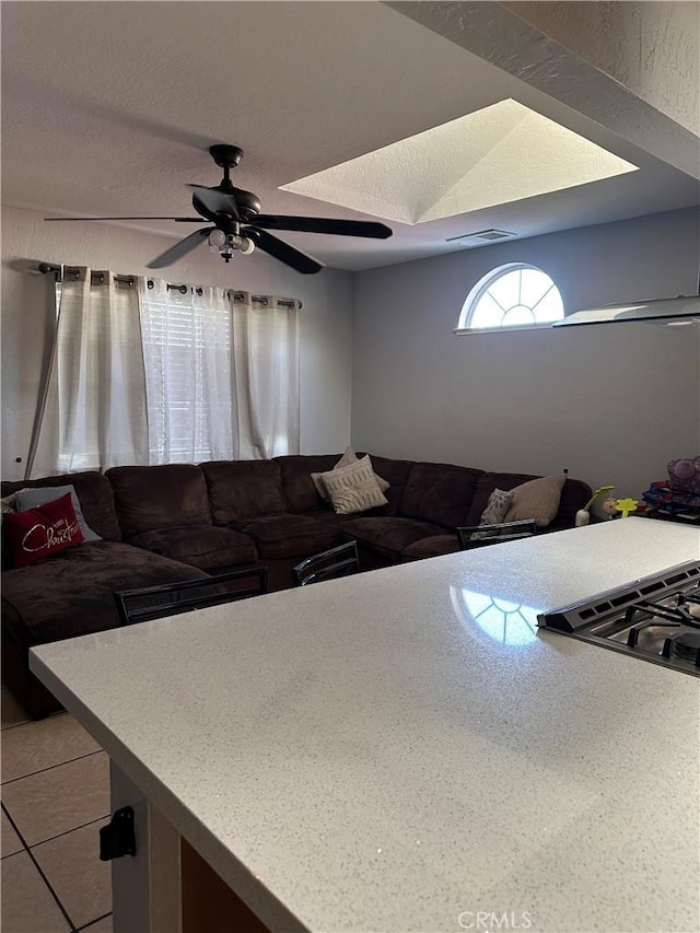 living area featuring a ceiling fan and visible vents