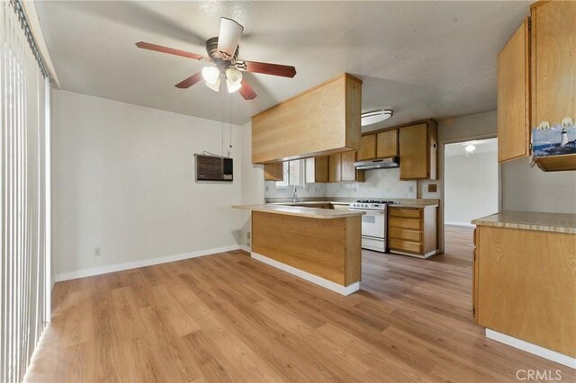 kitchen with under cabinet range hood, light wood-style floors, a peninsula, white range with gas cooktop, and ceiling fan
