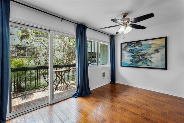 unfurnished room with visible vents, wood finished floors, baseboards, and ceiling fan
