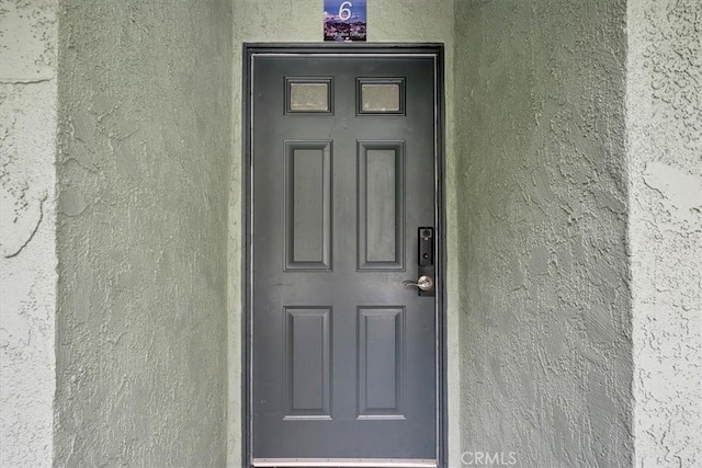view of exterior entry featuring stucco siding