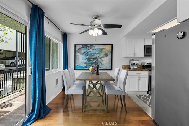 dining space with wood finished floors, baseboards, and ceiling fan