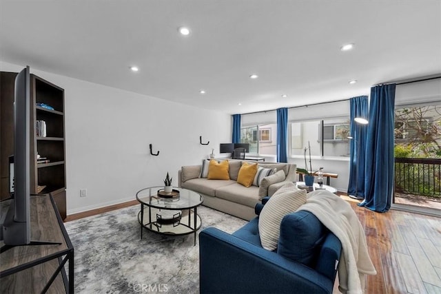 living area with recessed lighting, wood finished floors, and baseboards