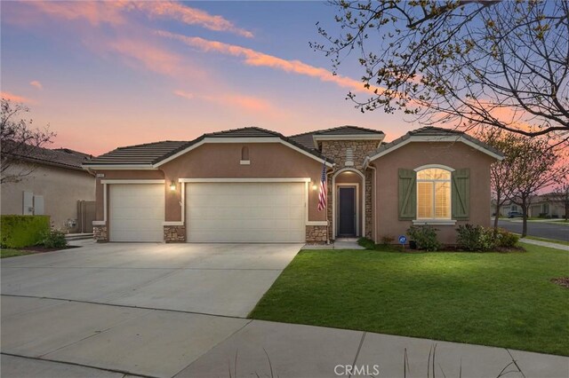 6207 Shelburne Dr, Bakersfield, CA 93306 - view of front of home with stone siding, a garage, stucco siding, a front lawn, and driveway