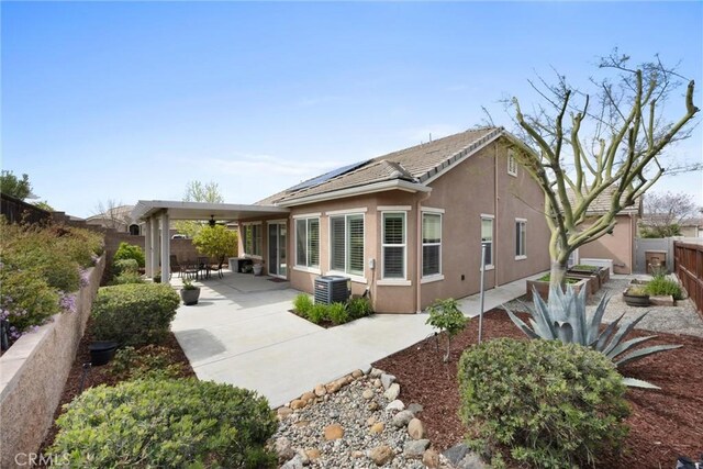 6207 Shelburne Dr, Bakersfield, CA 93306 - rear view of house featuring a ceiling fan, a fenced backyard, a patio area, stucco siding, and solar panels