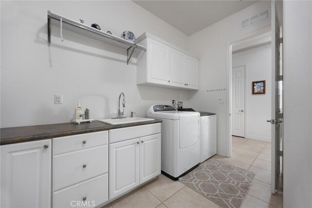 6207 Shelburne Dr, Bakersfield, CA 93306 - washroom featuring washer and dryer, cabinet space, and light tile patterned floors