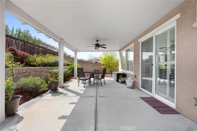 6207 Shelburne Dr, Bakersfield, CA 93306 - fenced backyard with outdoor dining space, ceiling fan, and a patio