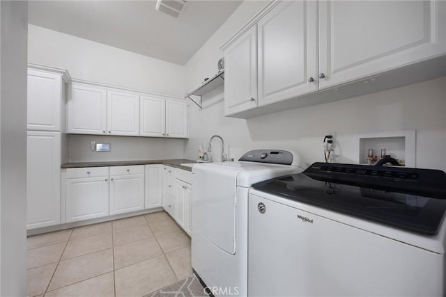 6207 Shelburne Dr, Bakersfield, CA 93306 - washroom featuring separate washer and dryer, light tile patterned flooring, and cabinet space