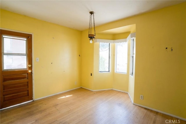 interior space with baseboards and wood finished floors